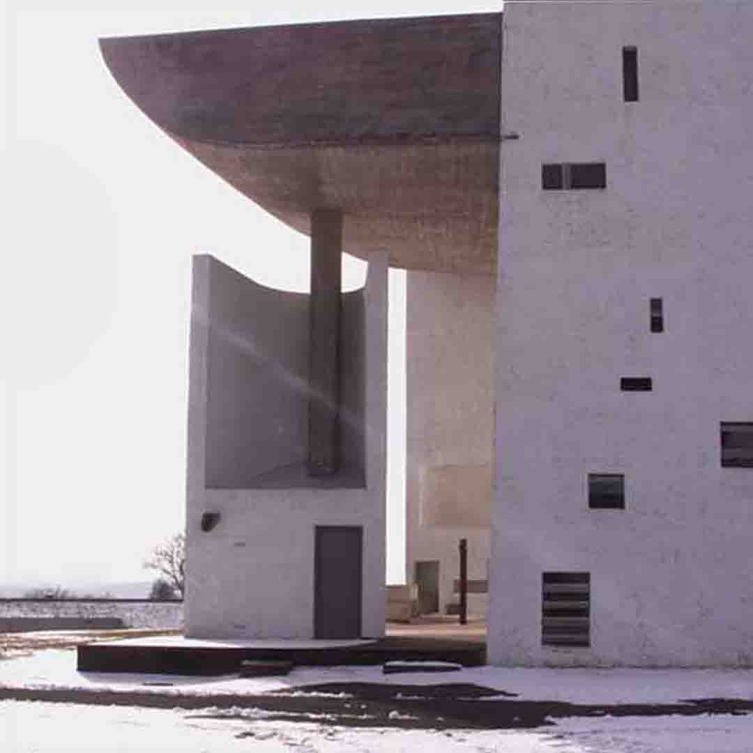 Chapelle Notre-Dame-du-Haut à Ronchamp conçue par Le Corbusier, façade latérale en hiver avec jeux de lumière naturelle